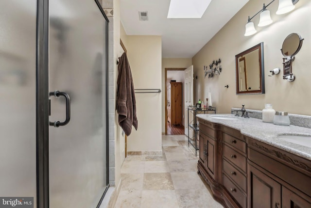 bathroom featuring a stall shower, a skylight, a sink, and visible vents