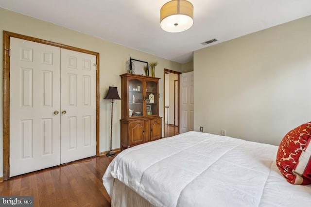 bedroom featuring a closet, visible vents, and wood finished floors