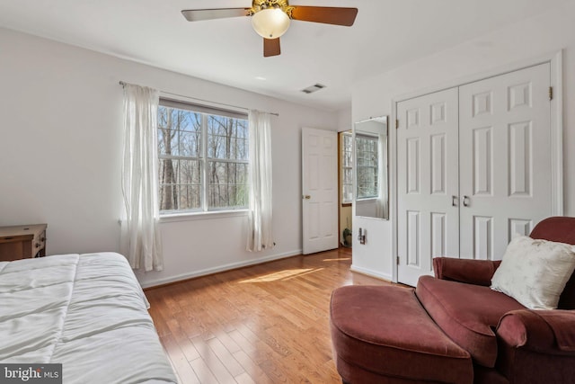 bedroom featuring a closet, visible vents, baseboards, and wood finished floors