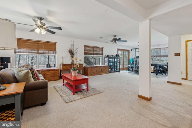 carpeted living area featuring a ceiling fan and baseboards