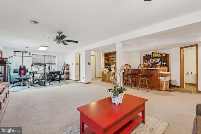 living area with baseboards, visible vents, light carpet, and a dry bar