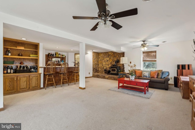 living room with carpet, a wood stove, and a bar