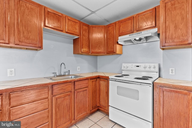 kitchen with light tile patterned flooring, sink, tile countertops, and electric range