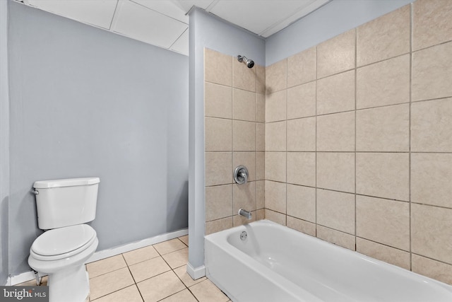 bathroom featuring tiled shower / bath, toilet, and tile patterned flooring