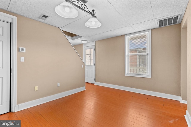 interior space featuring a paneled ceiling and hardwood / wood-style floors