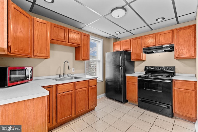 kitchen with light tile patterned flooring, a drop ceiling, sink, and black appliances