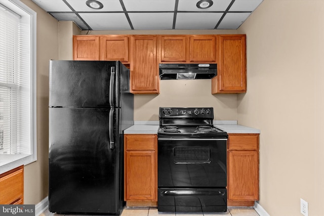 kitchen featuring light tile patterned floors, black appliances, and a healthy amount of sunlight