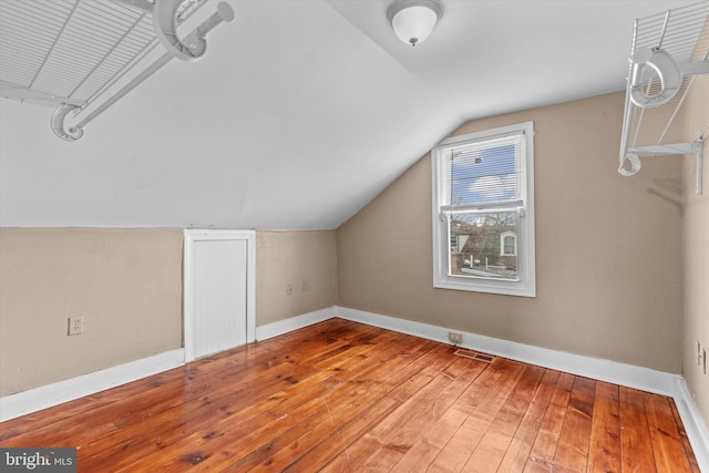 additional living space with hardwood / wood-style flooring and lofted ceiling