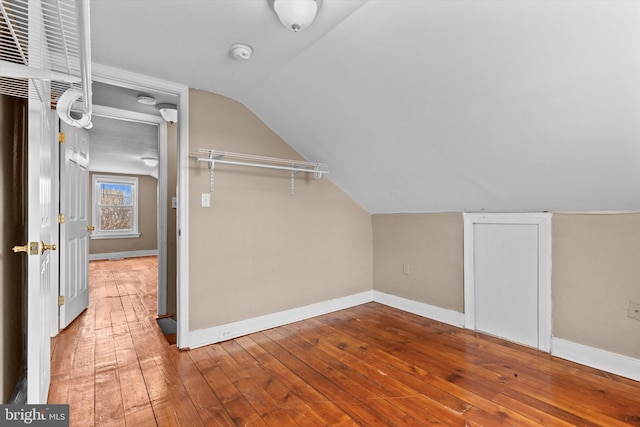 walk in closet featuring wood-type flooring and vaulted ceiling