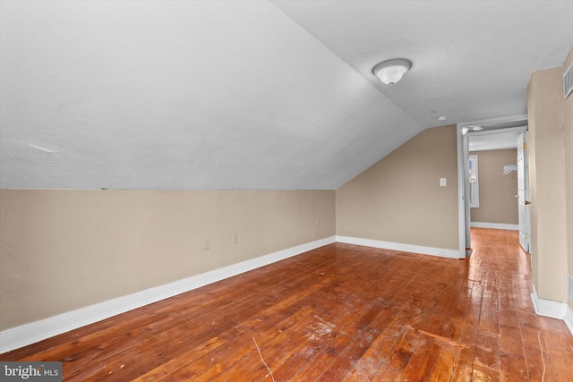 additional living space featuring lofted ceiling and hardwood / wood-style floors