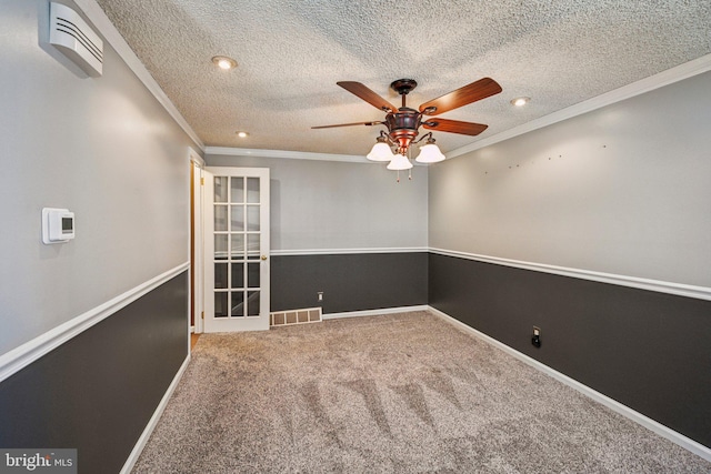 spare room with ceiling fan, crown molding, a textured ceiling, and carpet