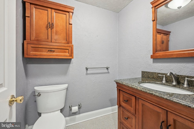 bathroom featuring vanity, toilet, and a textured ceiling