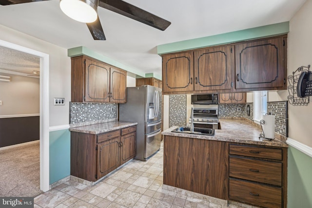 kitchen featuring ceiling fan, range, backsplash, stainless steel refrigerator with ice dispenser, and light carpet