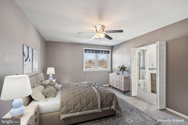 bedroom with ensuite bathroom, carpet, and ceiling fan