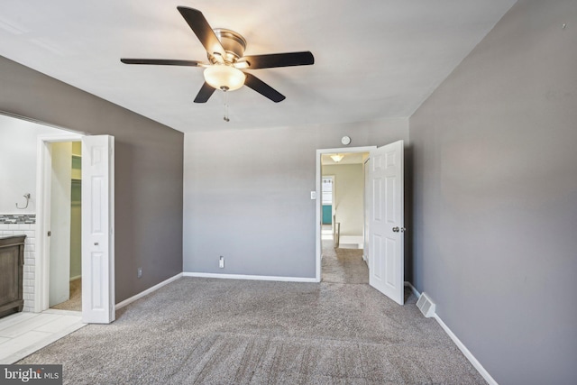 unfurnished bedroom featuring connected bathroom, a fireplace, and ceiling fan