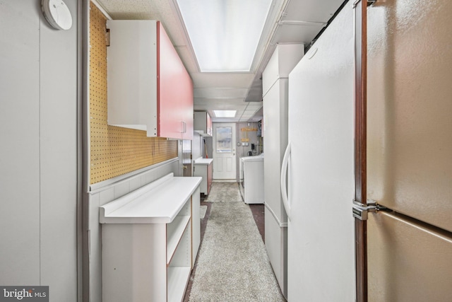 kitchen featuring light colored carpet and white refrigerator