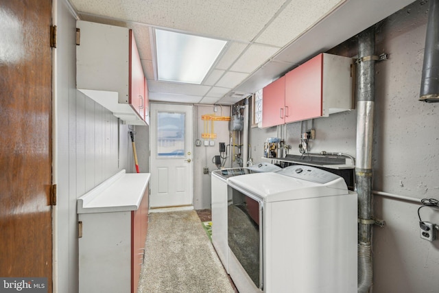 kitchen featuring light carpet, washer and clothes dryer, and a paneled ceiling