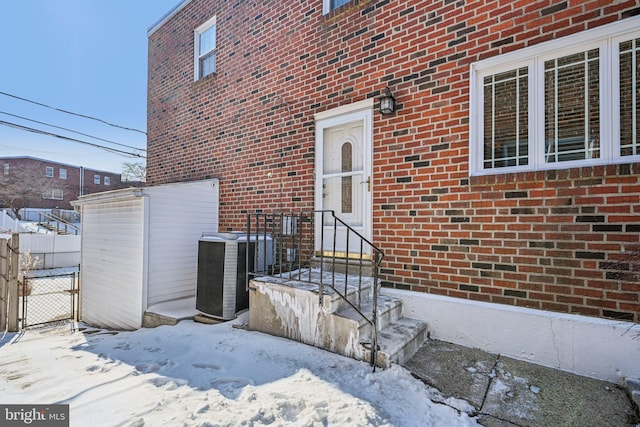 snow covered property entrance featuring cooling unit