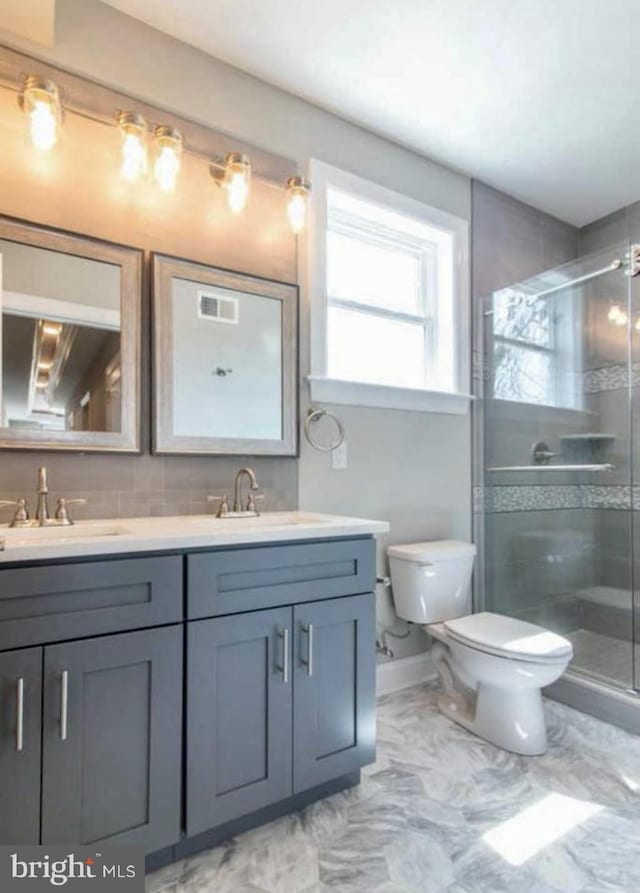 2312 Pierce St, Philadelphia, PA 19145 - bathroom with double vanity, marble look tile flooring, and a stall shower