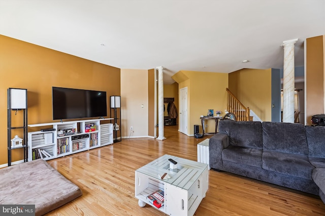 living room featuring light hardwood / wood-style flooring and ornate columns