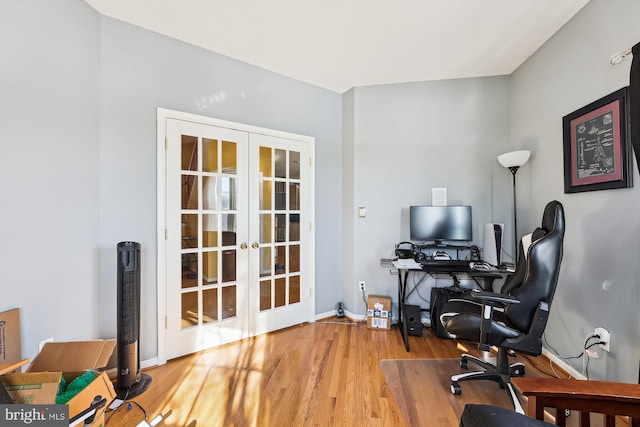 office with light hardwood / wood-style flooring and french doors