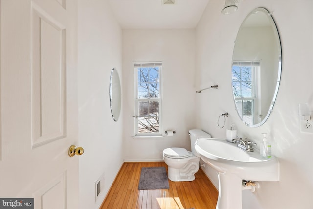 bathroom with toilet and hardwood / wood-style flooring