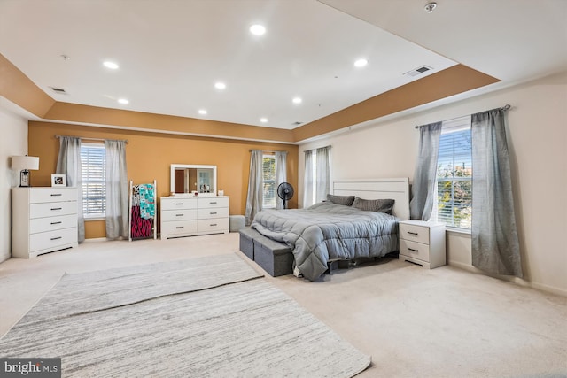 bedroom with light carpet and multiple windows