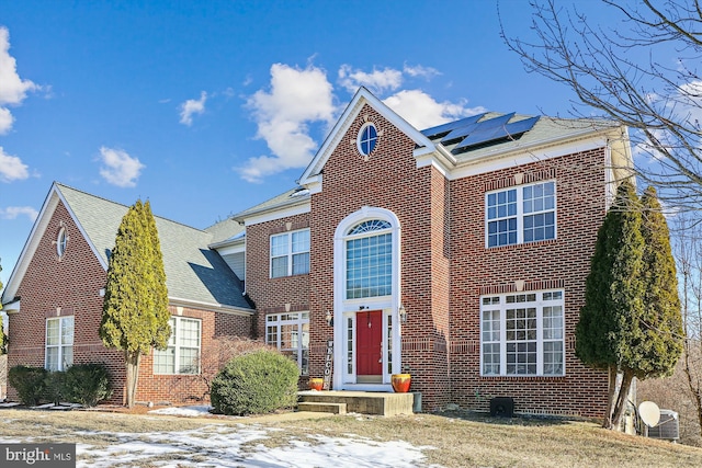 view of front of house with central AC and solar panels