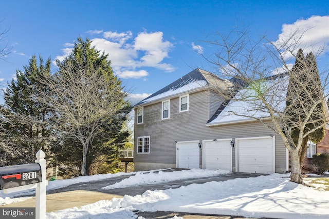 view of snowy exterior featuring a garage