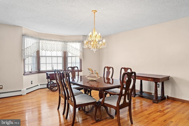 dining area with a textured ceiling, light wood-type flooring, and an inviting chandelier