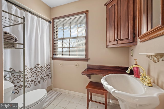 bathroom featuring walk in shower, sink, tile patterned flooring, and toilet