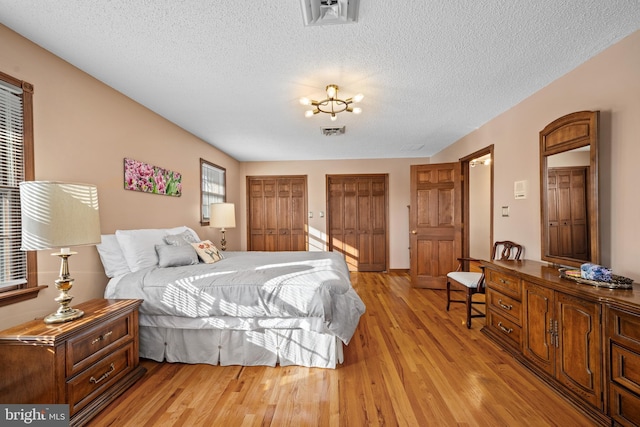 bedroom featuring a textured ceiling and light hardwood / wood-style flooring