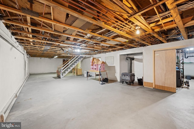 basement featuring a wood stove and baseboard heating