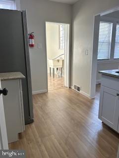 corridor with light hardwood / wood-style flooring