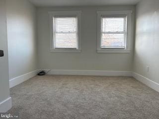 carpeted spare room featuring a healthy amount of sunlight