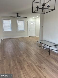 entryway featuring wood-type flooring and ceiling fan with notable chandelier