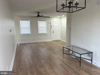 entryway with ceiling fan with notable chandelier and hardwood / wood-style floors