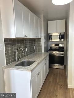 kitchen featuring sink, stainless steel appliances, and white cabinetry