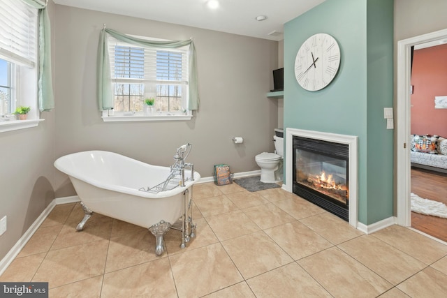 bathroom with toilet, tile patterned floors, and a bathing tub