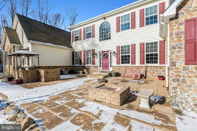 colonial inspired home with a patio area and a fire pit