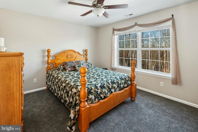 bedroom with ceiling fan, multiple windows, and dark carpet