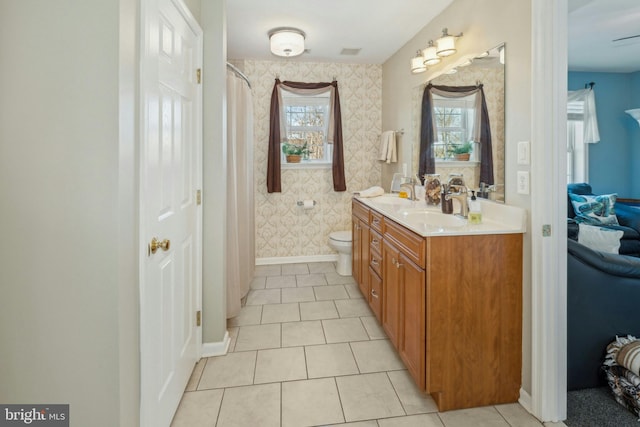 bathroom with toilet, vanity, and tile patterned flooring