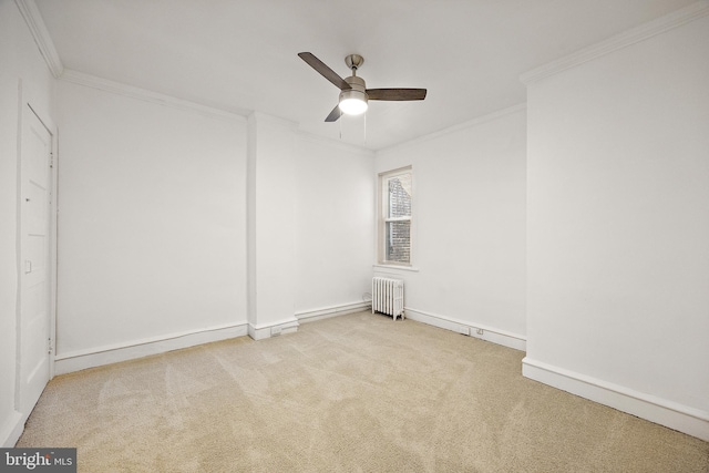 spare room featuring light carpet, radiator heating unit, ceiling fan, and ornamental molding