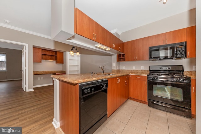 kitchen featuring kitchen peninsula, sink, light stone countertops, ornamental molding, and black appliances