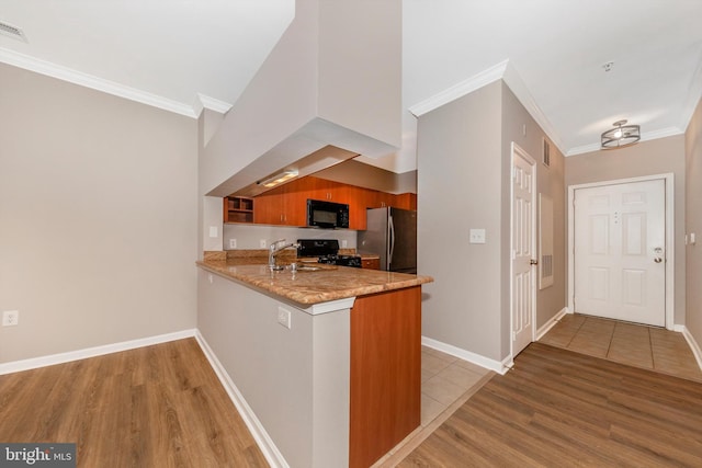 kitchen featuring kitchen peninsula, crown molding, black appliances, and light hardwood / wood-style floors