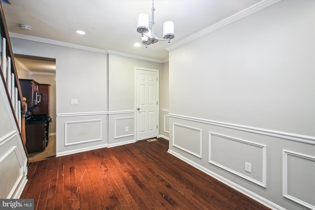 empty room featuring dark hardwood / wood-style flooring, crown molding, and an inviting chandelier