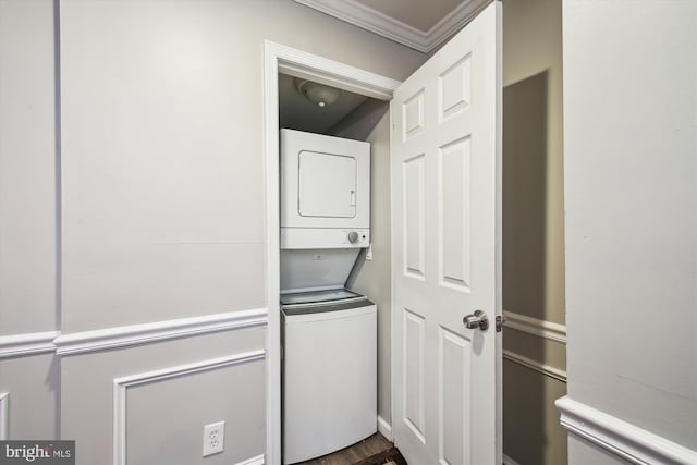 laundry area with crown molding and stacked washing maching and dryer