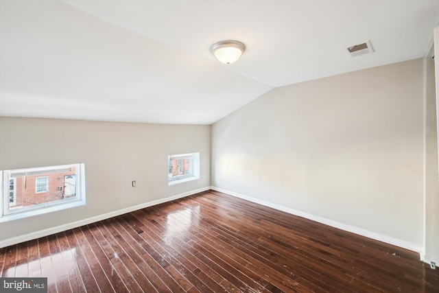 additional living space featuring vaulted ceiling and dark hardwood / wood-style flooring