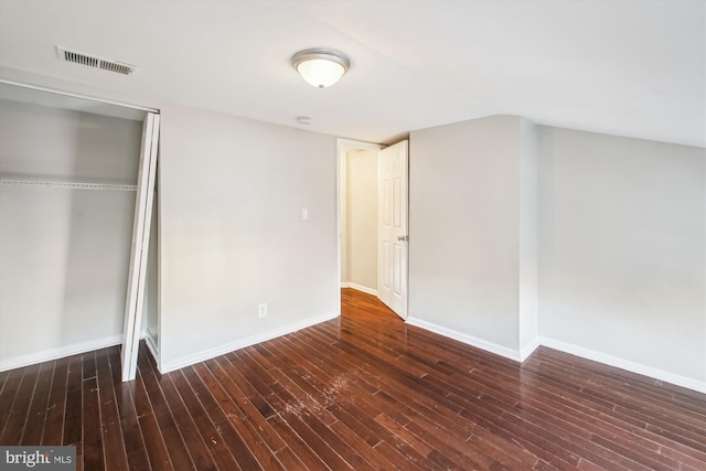 unfurnished bedroom with dark wood-type flooring and a closet