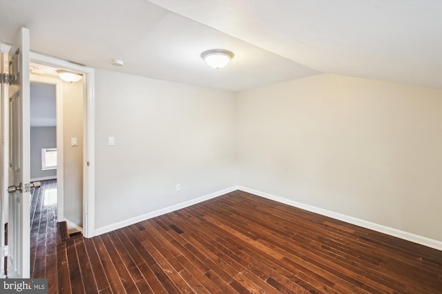 unfurnished room with dark hardwood / wood-style flooring and vaulted ceiling